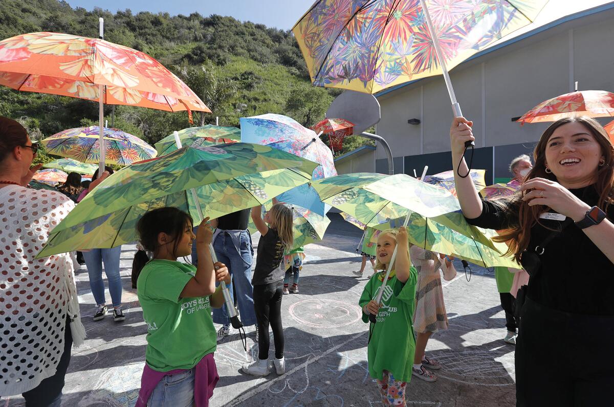 Kids spin and dance to drums as they open colorful umbrellas during the "Look Up" flash art experience.