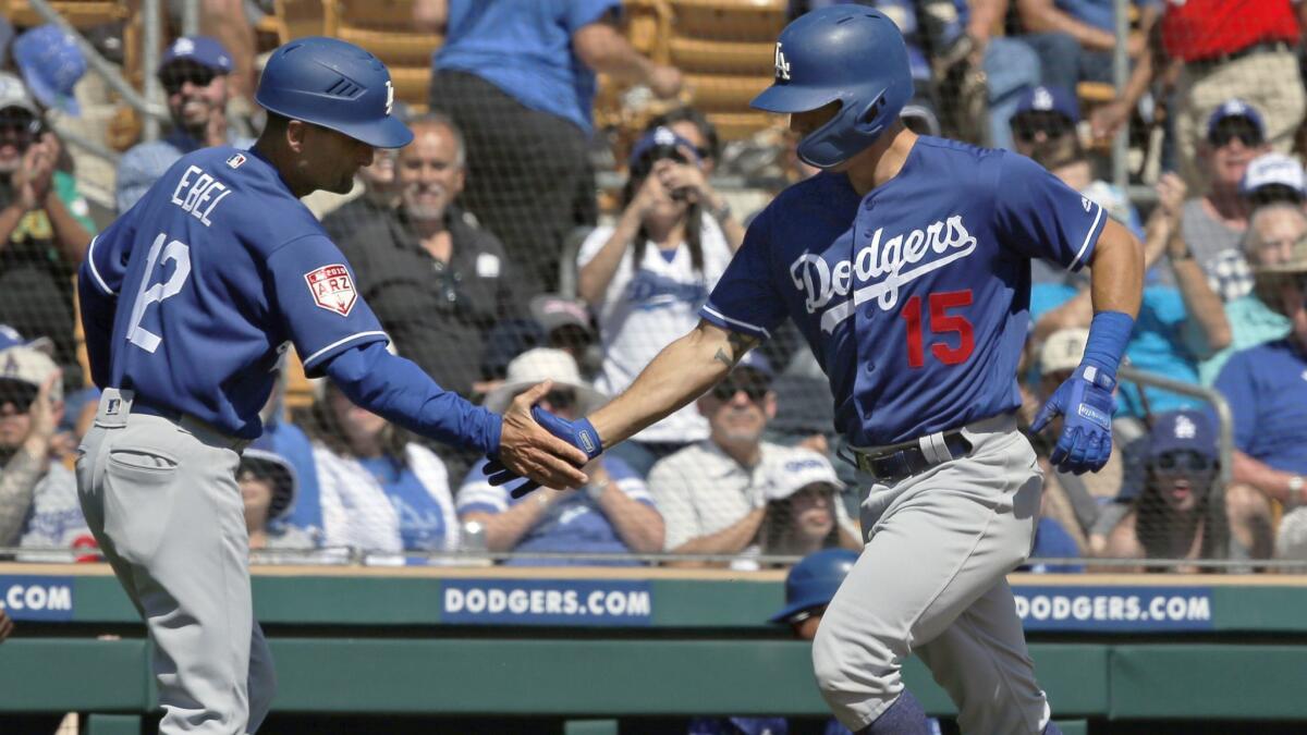 Dodgers' Austin Barnes (15) is congratulated by third base coach Dino Ebel (12) following his home run in the second inning of a spring training game against the Chicago White Sox on Saturday in Glendale, Ariz.