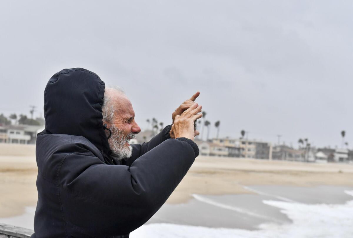 "I love this weather,” said Basil Bailey of Belmont Shore, taking pictures of the incoming storm Friday in the gusty winds at the Seal Beach Pier.