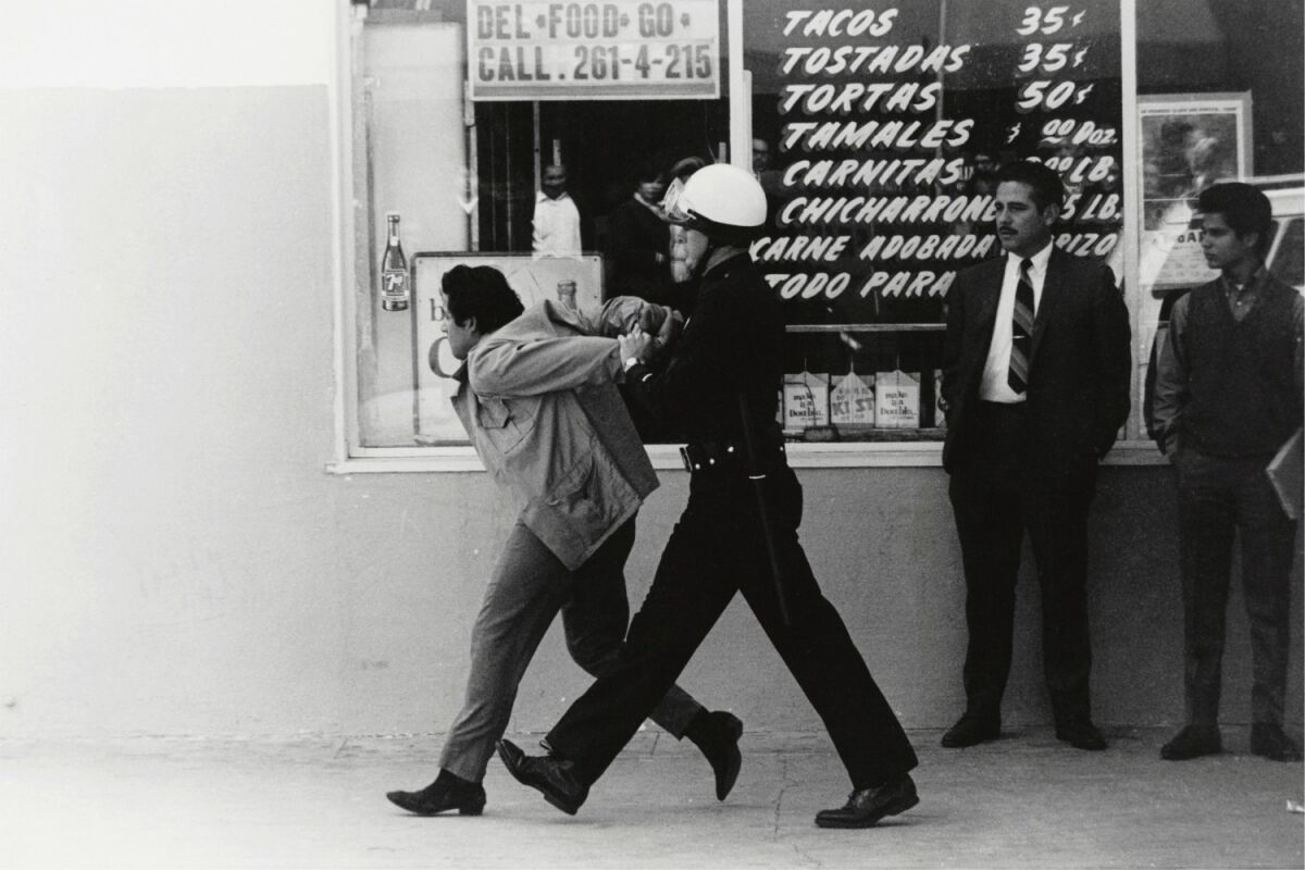 "LAPD arresting a Chicano student protester, Boyle Heights," 1970, by George Rodriguez, from the artist's retrospective at the Vincent Price Art Museum.