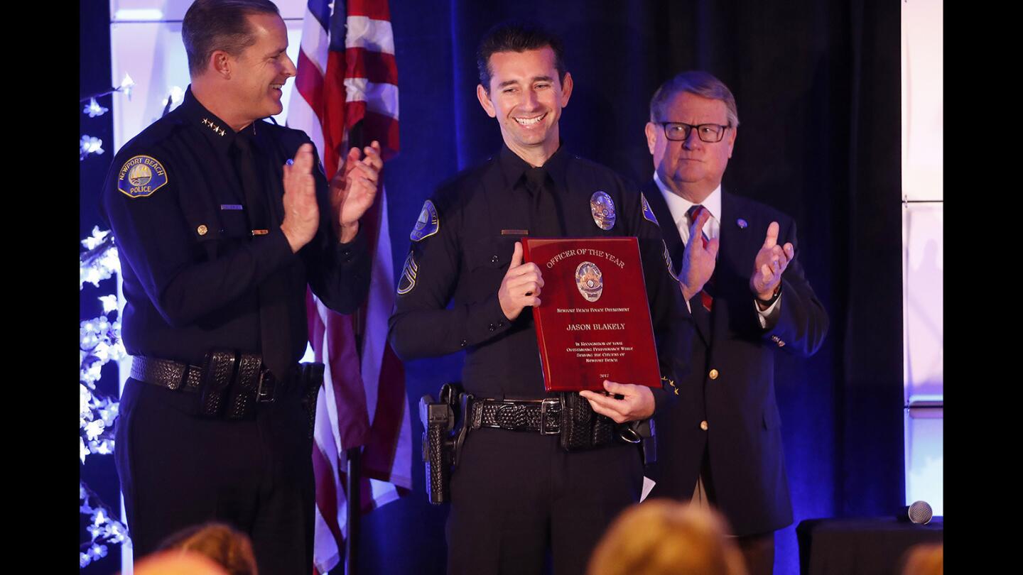 Officer Jason Blakely, center, accepts his award for Officer of the Year during the 47th annual Police Appreciation Breakfast at Hyatt Regency Newport Beach on Thursday morning.