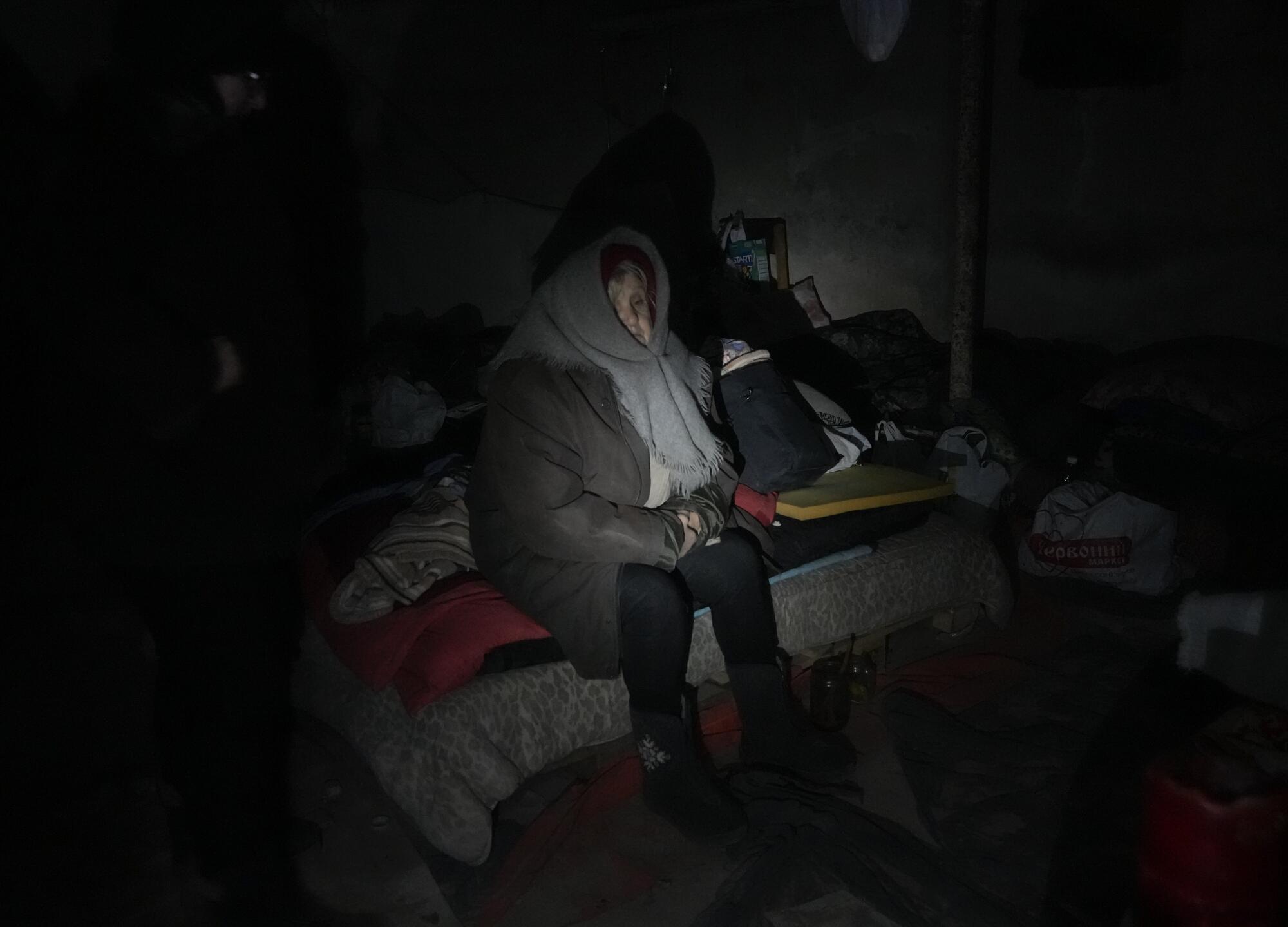 An elderly resident hides in a basement for shelter with no electricity, water or food in the center of the town of Irpin.