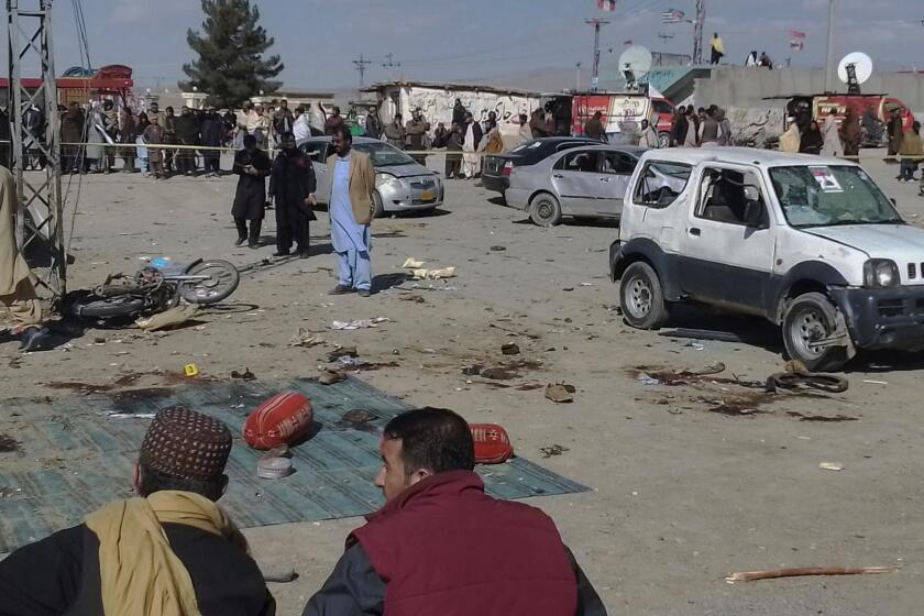 Security officials examine the scene of a bomb blast in Khanozai, Pashin, a district of Pakistan's Baluchistan province, Wednesday, Feb. 7, 2024. A pair of bombings at the election offices of a political party and an independent candidate in southwest Pakistan killed some people and wounded more, officials said Wednesday, the day before parliamentary elections are to be held. (AP Photo/Shah Hussain)