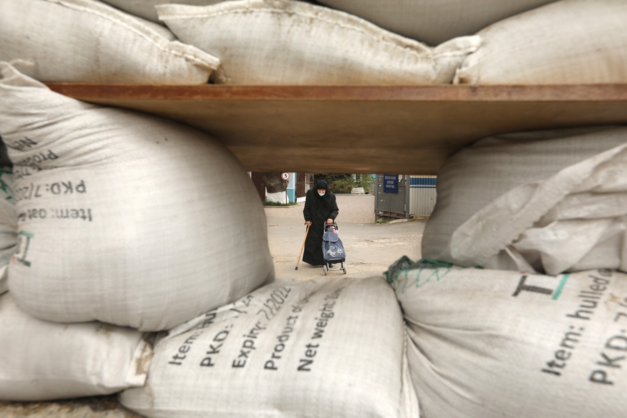An elderly woman walks by sandbags set up for protection in Odesa. 