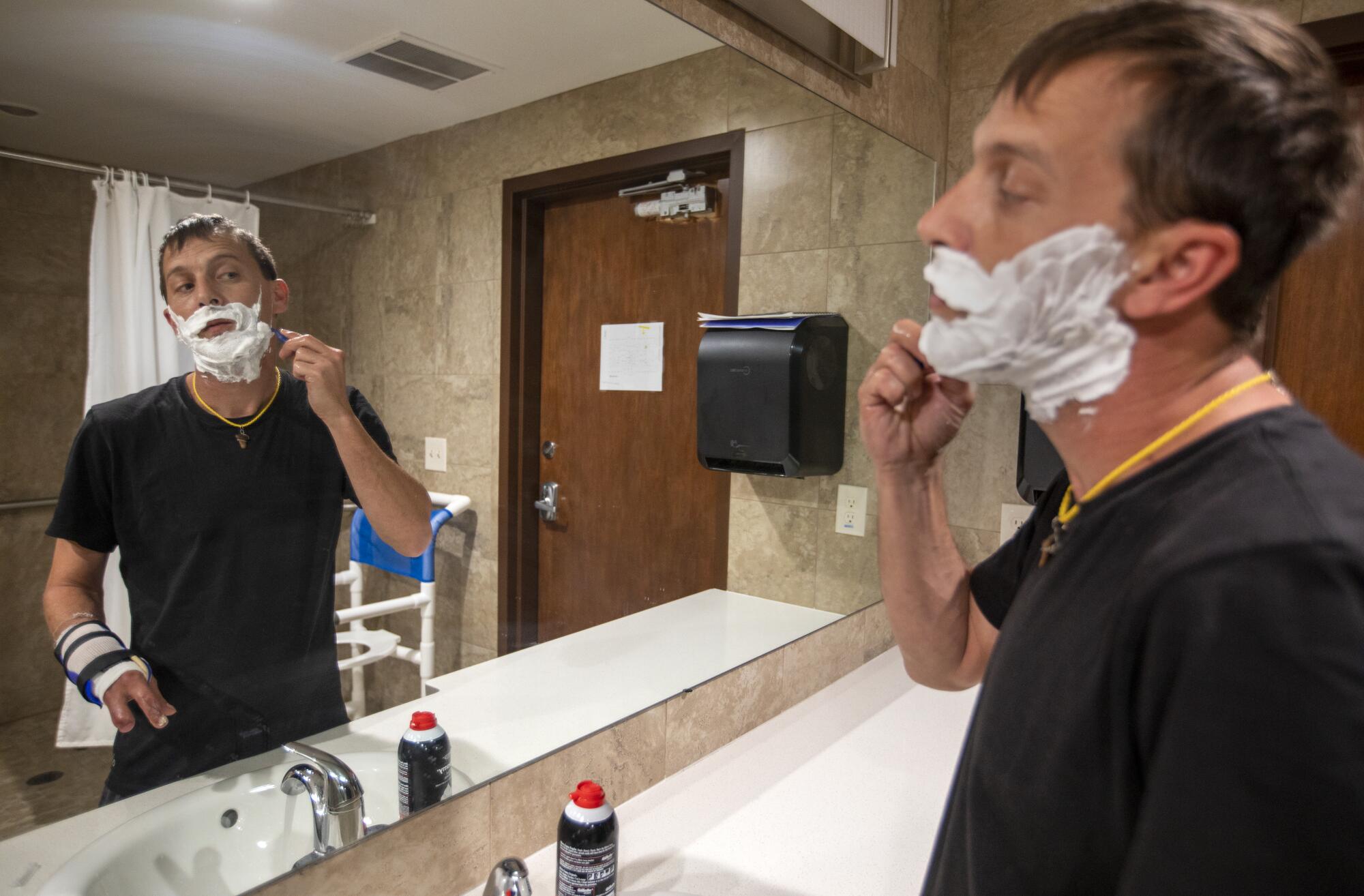 James Haley, a resident at the Inn Between, shaves before work.  