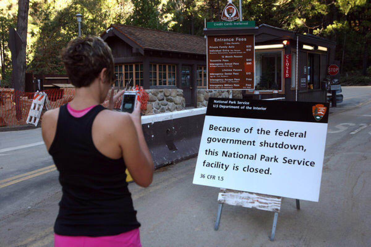 Renee Lucas, a visitor from Indiana, takes a picture of a closed gate to Yosemite National Park.