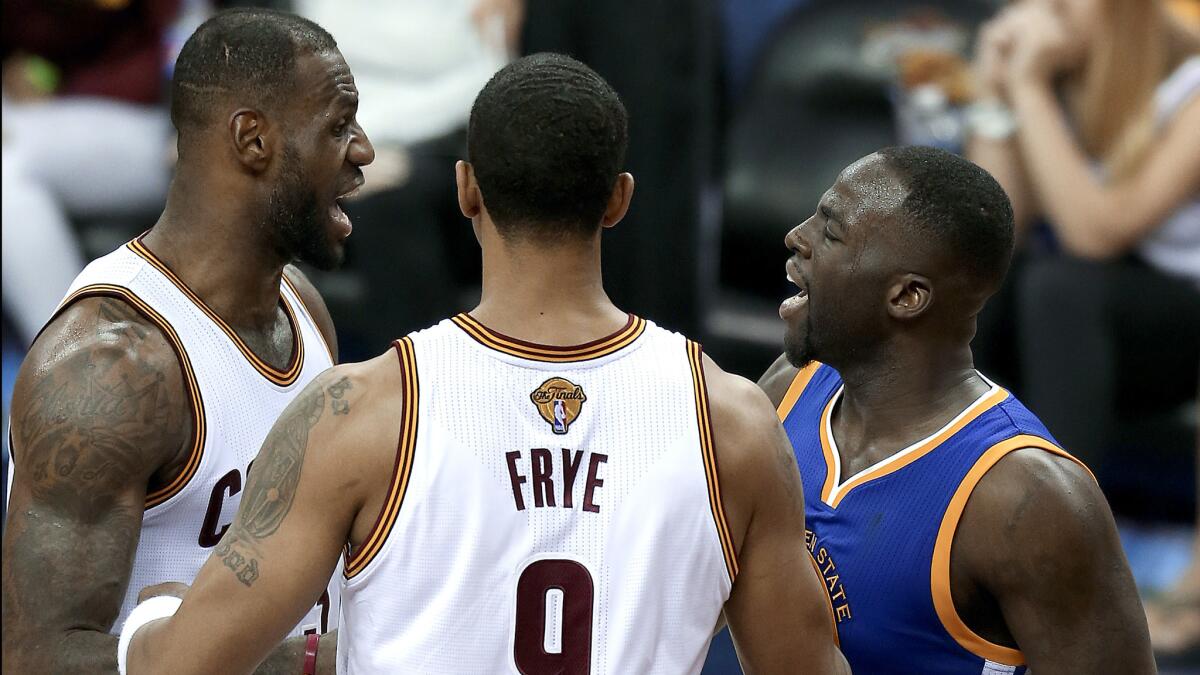 Cavaliers forward LeBron James, left, and Warriors forward Draymond Green exchange words after getting tangled late in Game 4 on Friday.