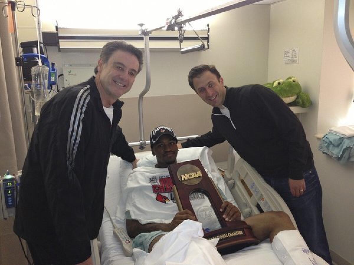 Kevin Ware, shown in the hospital with Louisville Coach Rick Pitino, left, and former assistant coach Richard Pitino, is resting comfortably in an Indianapolis hospital after surgery on his broken leg Sunday night.