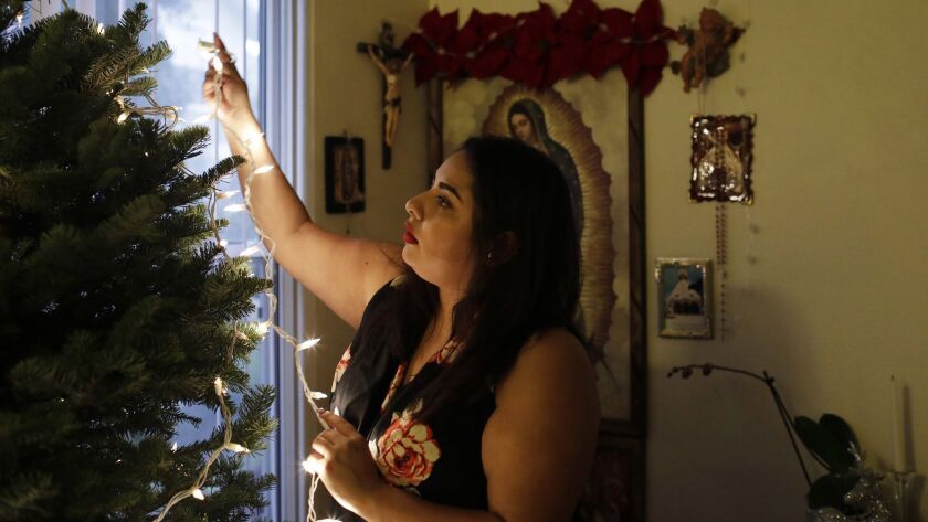 Gabriela Cruz decorates her family's Christmas tree at her home in Santa Cruz.