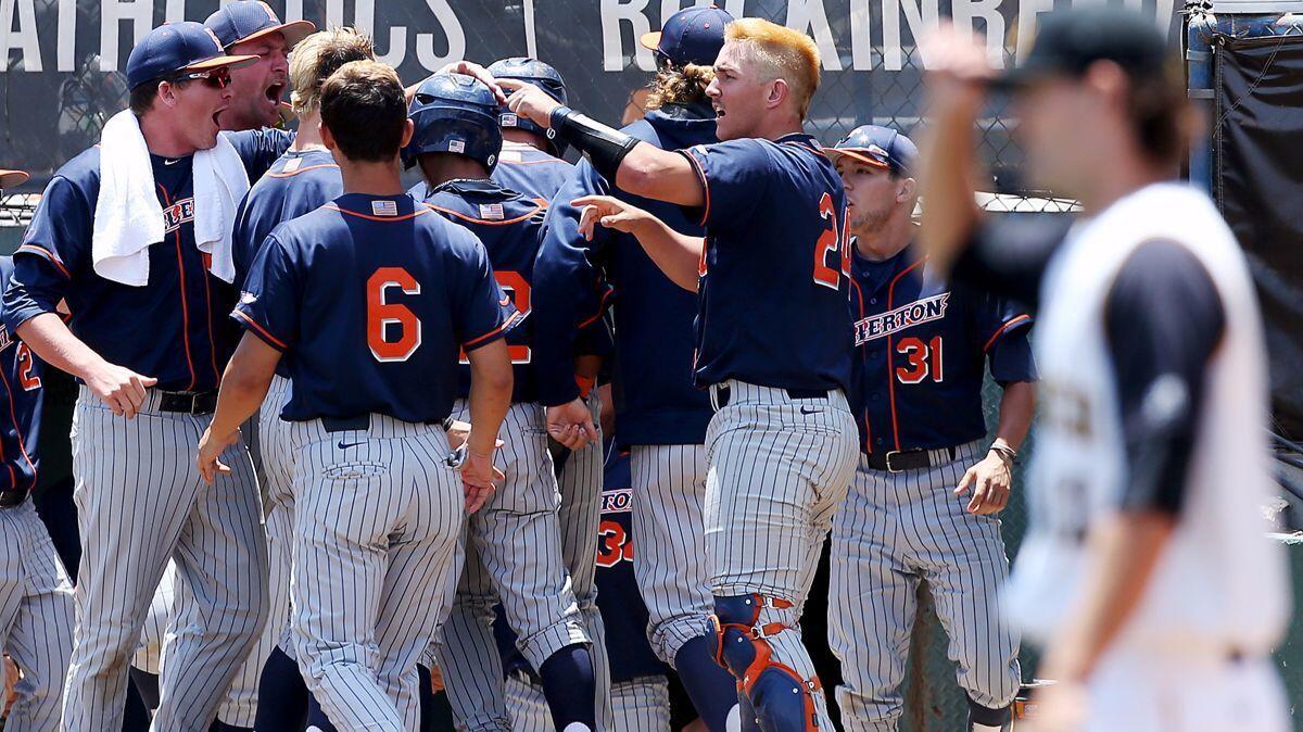 Cal State Fullerton players celebrate after scoring two runs against Long Beach State in the fourth inning of the final game of a super regional Sunday.