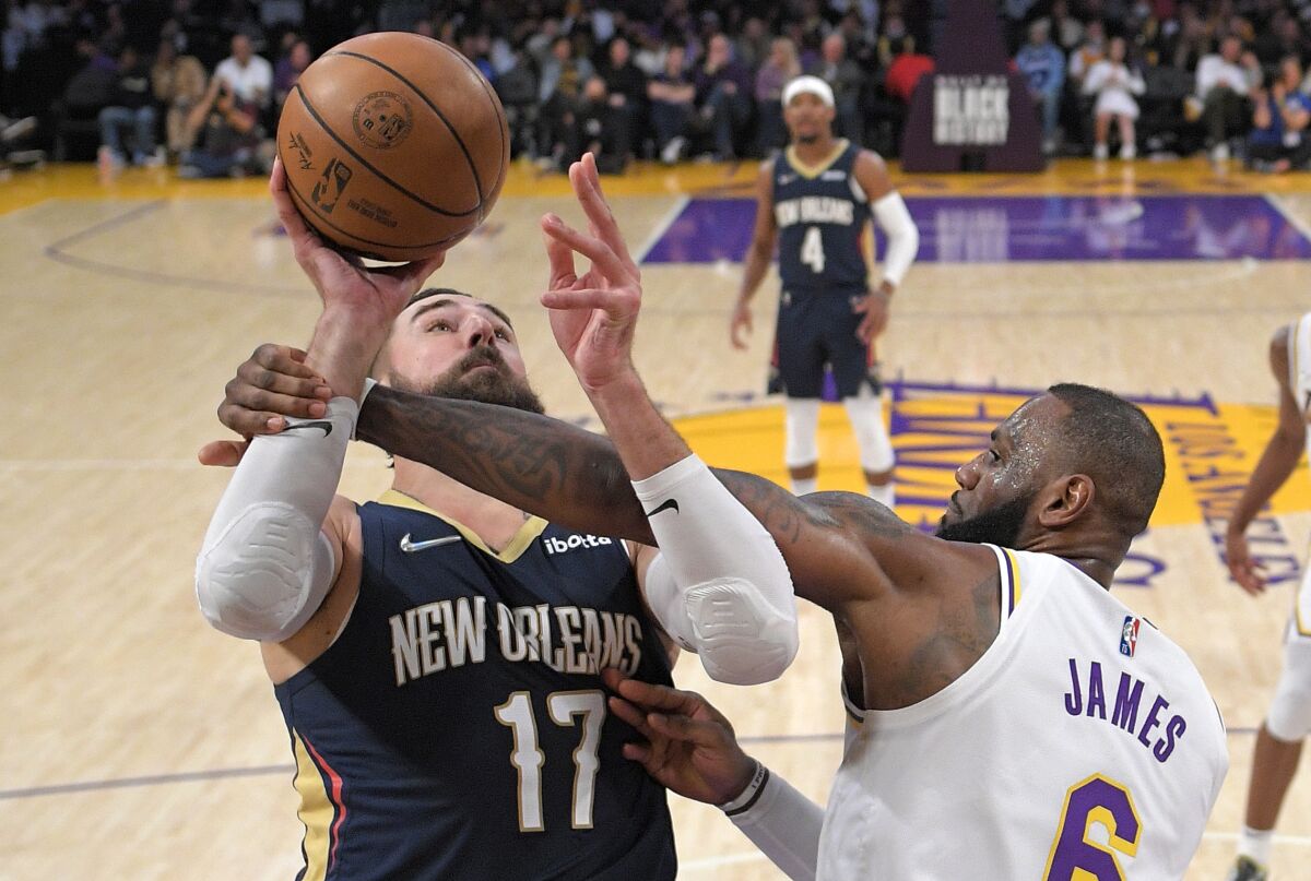 New Orleans Pelicans center Jonas Valanciunas, left, is fouled by Lakers star LeBron James while putting up a shot Sunday.
