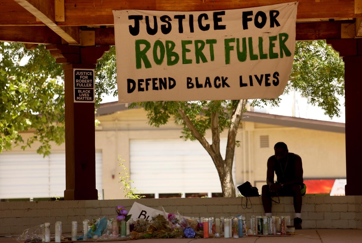 A man pays his respects at a memorial for Robert Fuller.