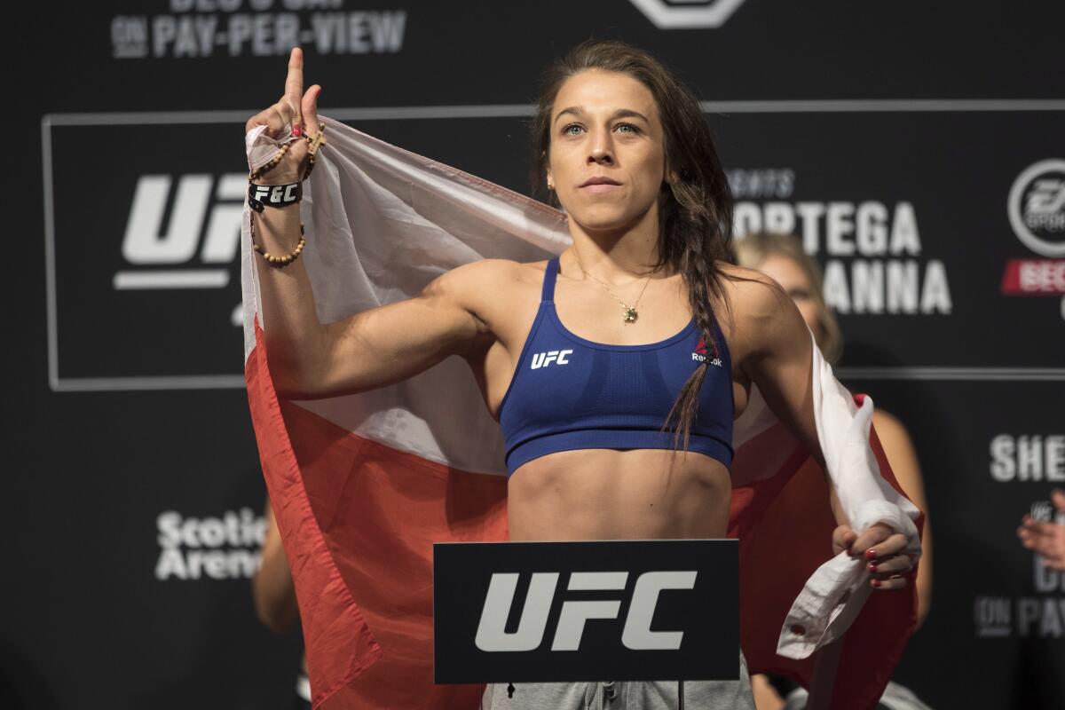 Joanna Jedrzejczyk poses on the scale during the weigh-in for her flyweight mixed martial arts bout against Valentina Shevchenko at UFC 231 in Toronto on Friday, Dec. 7, 2018. (Chris Young/The Canadian Press via AP)