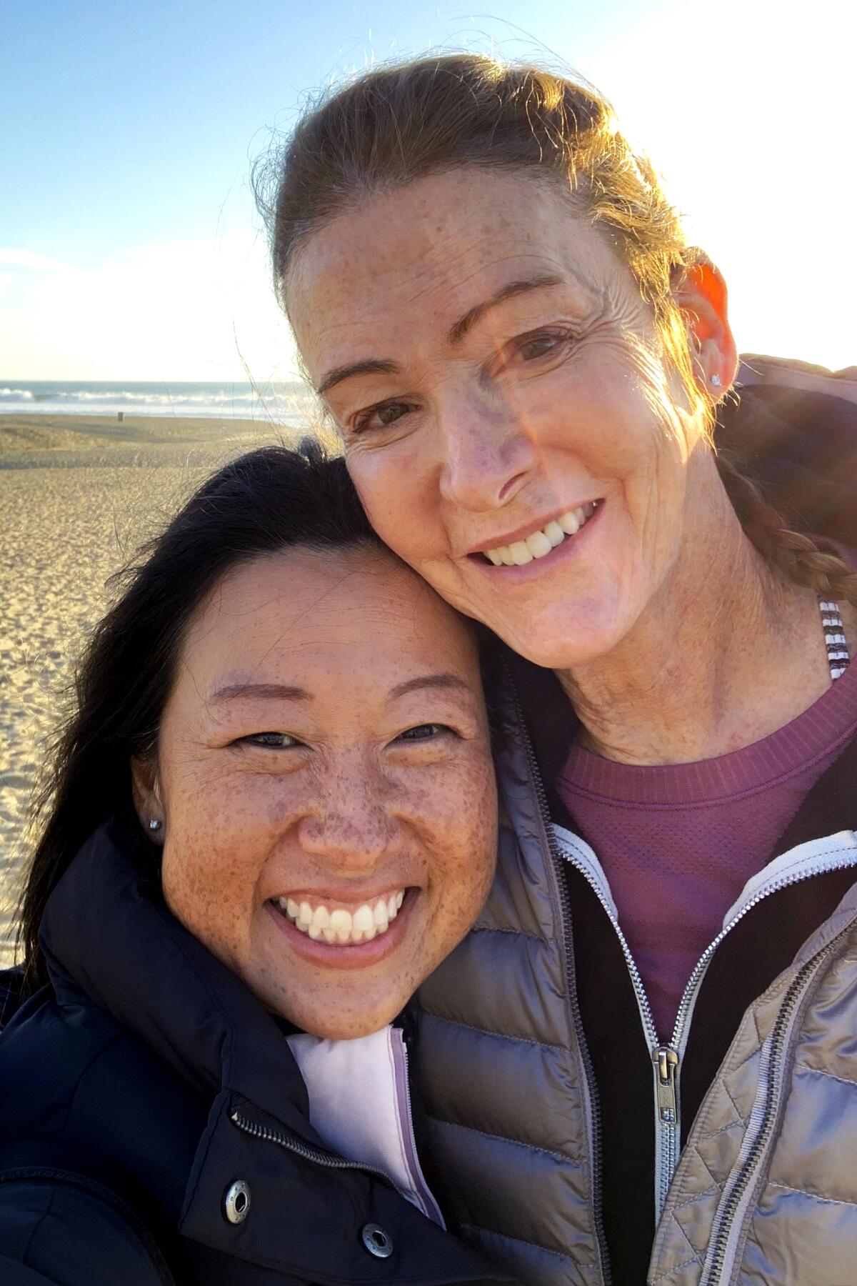 Jennifer Moore, right, and her wife, Mika, at the beach for their yoga sessions.