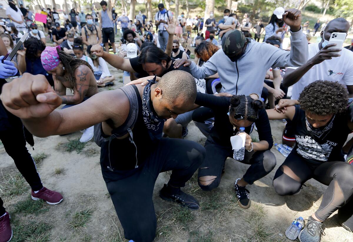Protesters pray together at MacArthur Park in Los Angeles.