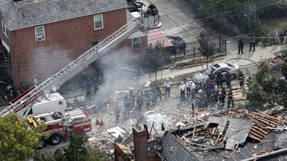 Firefighters and other emergency personnel at the scene of a house explosion in the Bronx borough of New York. Authorities believe that the house was the site of an indoor marijuana growing operation.