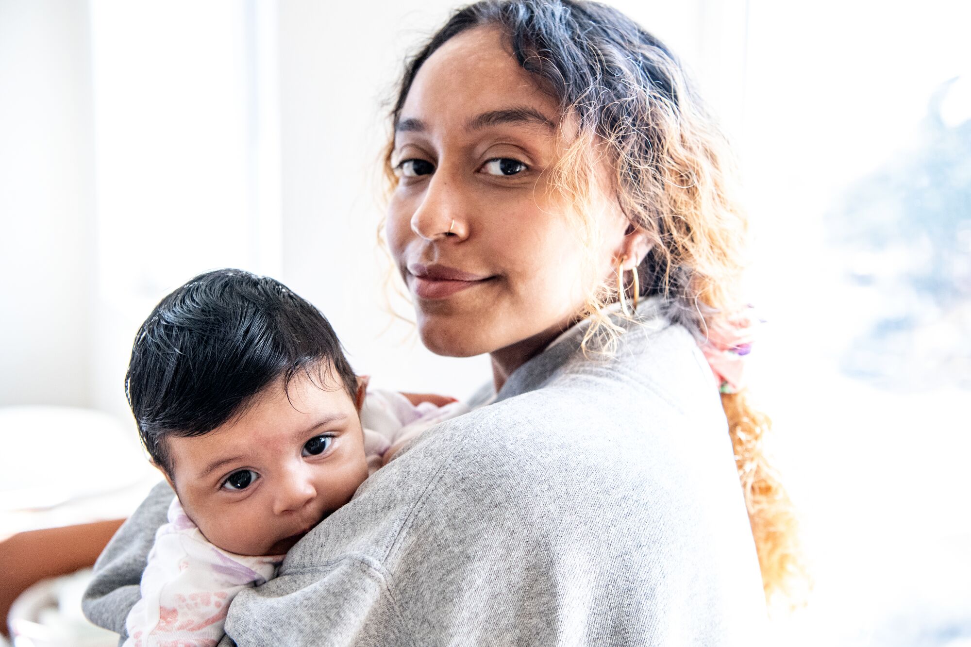 Portrait of Evelynn Escobar and her baby, Isla Andrade-Escobar, inside Escobar's residence