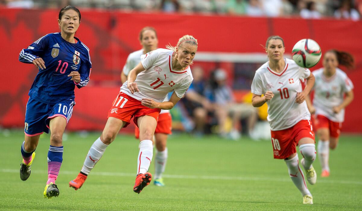 Switzerland's Lara Dickenmann, center, takes a shot as Switzerland's Ramona Bachmann, right, and Japan's Homare Sawa, left, chases during the FIFA Women's World Cup 2015 on Monday.