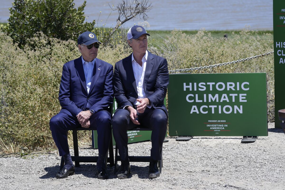 President Joe Biden sits with California Gov. Gavin Newsom while they listen to speakers at the Lucy Evans Baylands Nature Interpretive Center and Preserve in Palo Alto, Calif., Monday, June 19, 2023. (AP Photo/Susan Walsh)