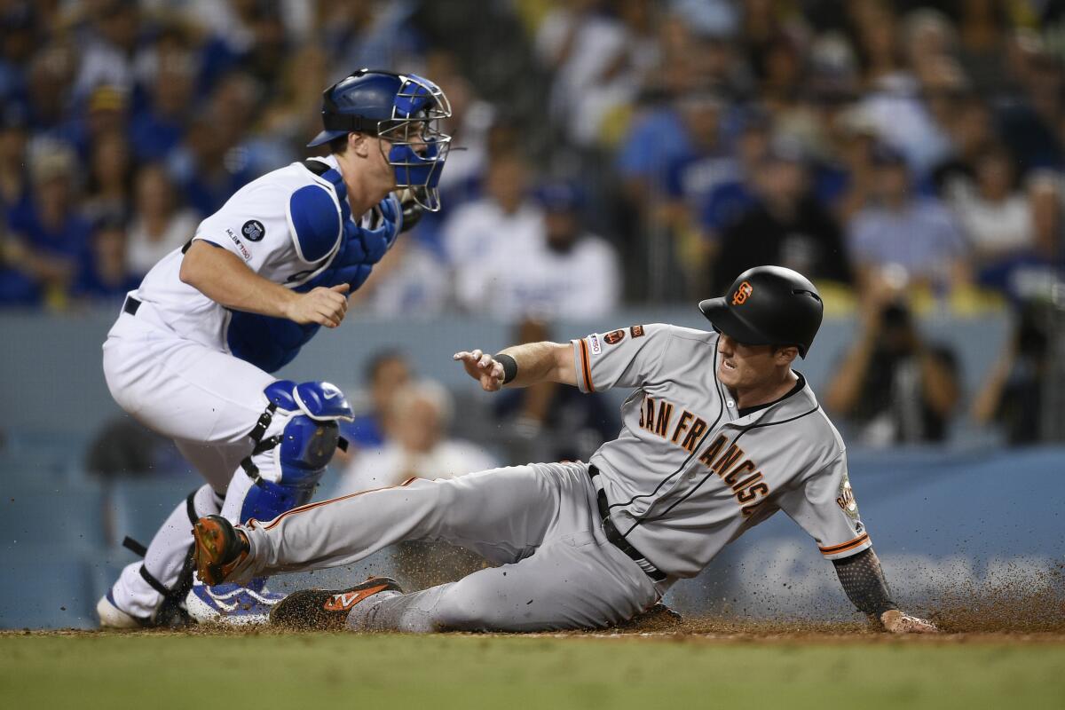 San Francisco Giants' Mike Yastrzemski, right, slides into home in front of Dodgers catcher Will Smith during the fifth inning of Friday's game.
