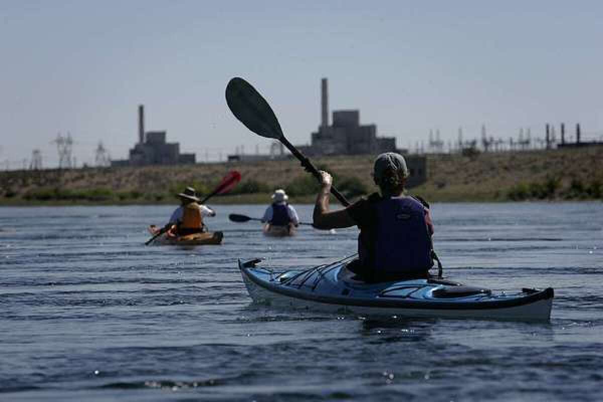 Kayakers paddle the Columbia River near the nuclear reactor that was a home to the Manhattan Project. The river is under threat from radioactive waste leaks.