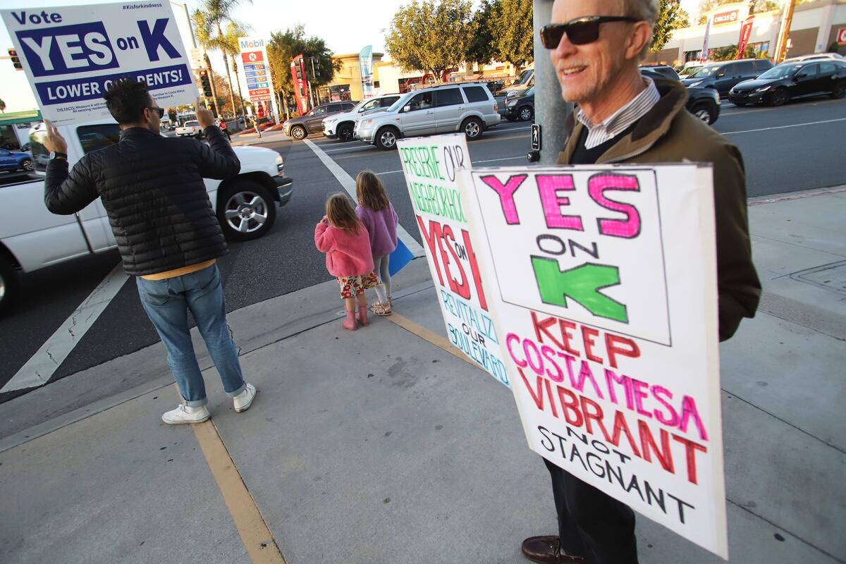 Costa Mesa residents take part in a rally in support of Measure K at the intersection of Harbor Boulevard and Baker Street.