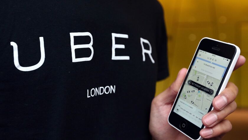 An Uber driver displays the car-hailing app.