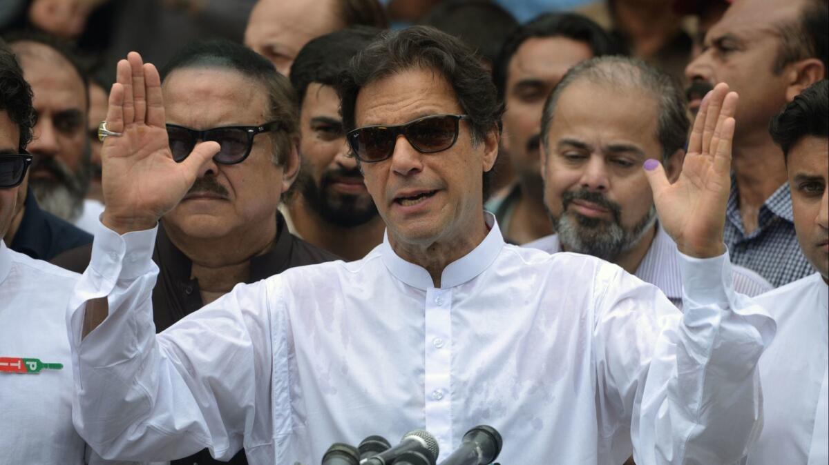 Pakistan's cricket-star-turned politician Imran Khan speaks to the media after casting his vote. In a controversial election, he was voted in as prime minister.