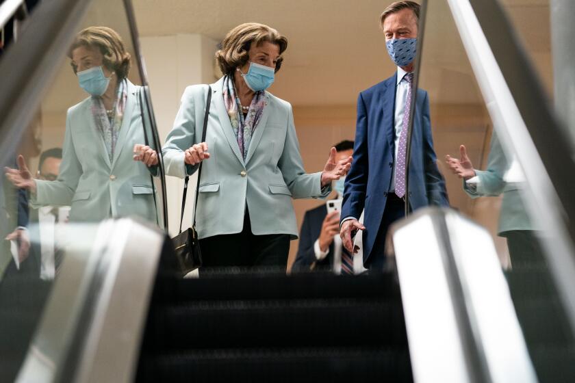 WASHINGTON, DC - AUGUST 03: Sen. Dianne Feinstein (D-CA) speaks with Sen. John Hickenlooper (D-CO) as they make their way through the Senate Subway on Capitol Hill on Tuesday, Aug. 3, 2021 in Washington, DC. (Kent Nishimura / Los Angeles Times)