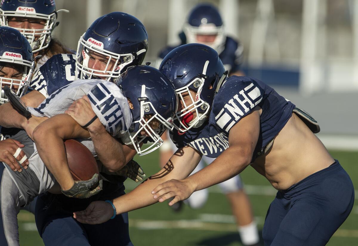 Newport Harbor linebacker Chad Koste, right, assists in a tackle against Connor Cheiner during practice on Wednesday at Davidson Field.