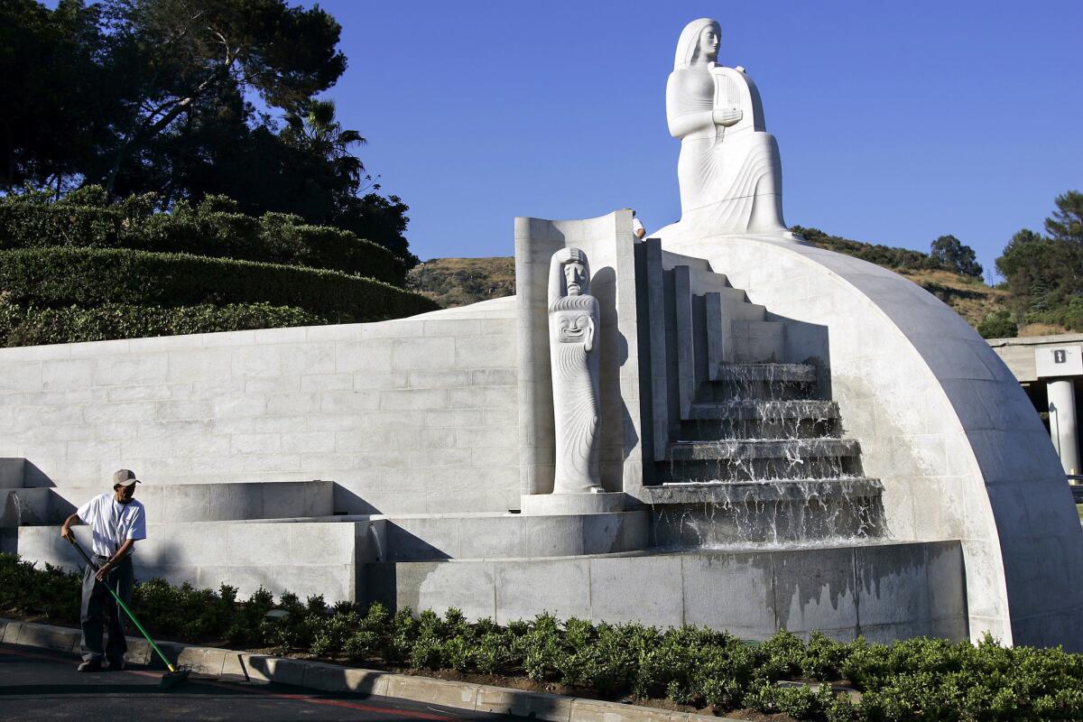 June 19, 2006: Juan Manuel sweeps near the restored fountain, which features the Muse of Music, Dance, Drama.