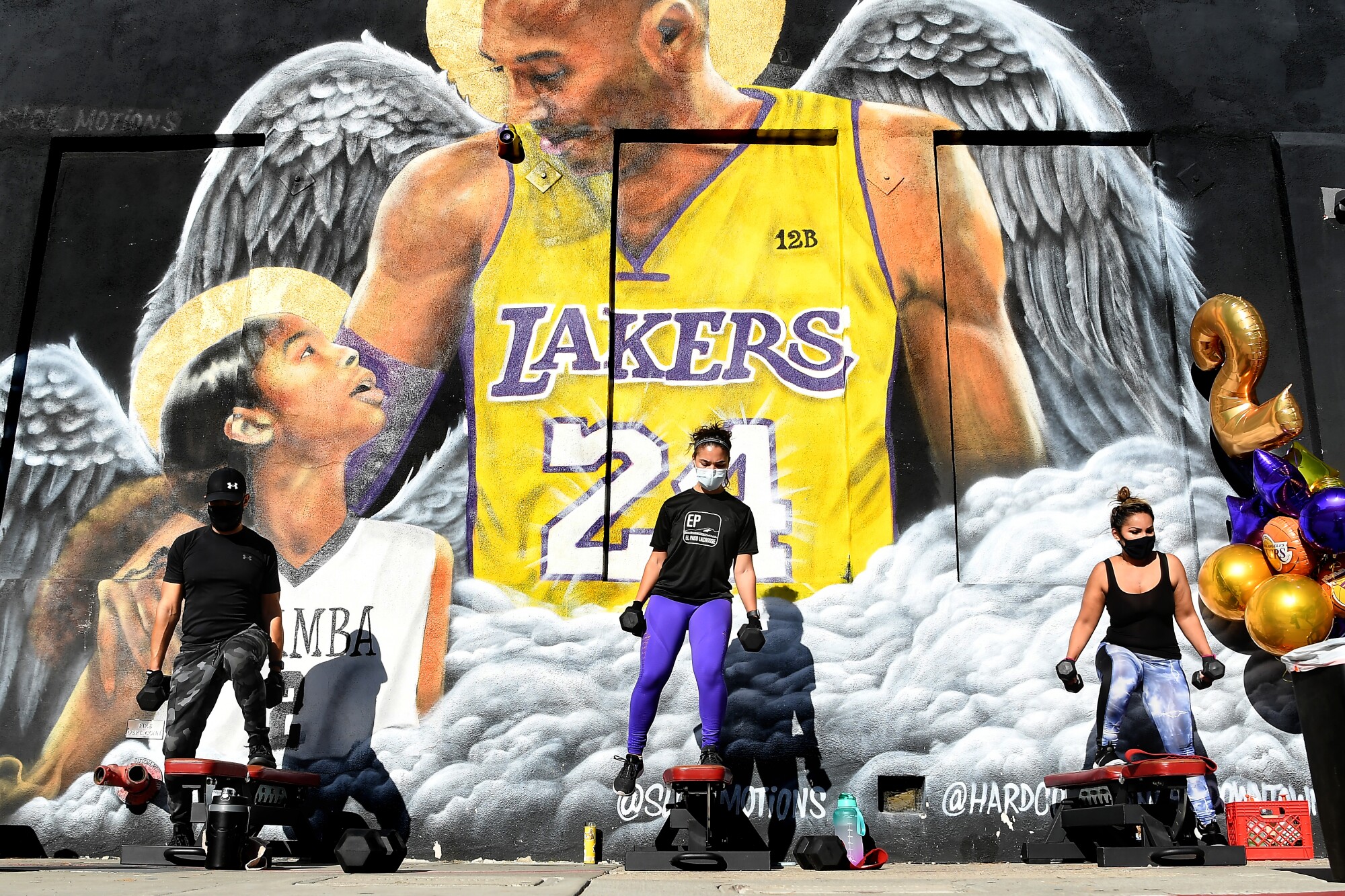 People work out in front of a mural of Kobe Bryant and his daughter Gianna