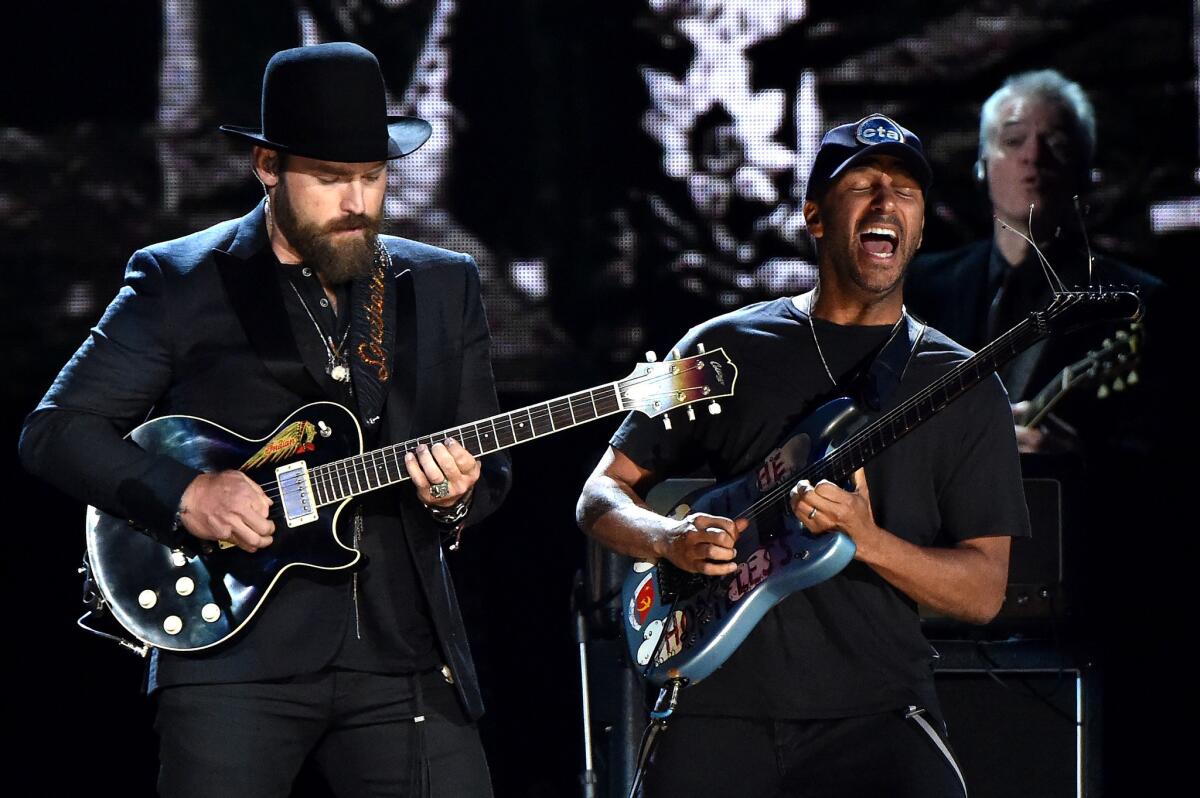 Musicians Zac Brown, left, and Tom Morello perform a Paul Butterfield Blues Band song onstage.