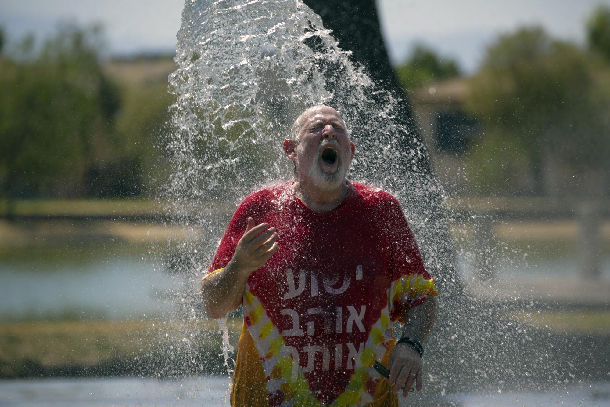 Man reacts as water from a sprinkler hits him