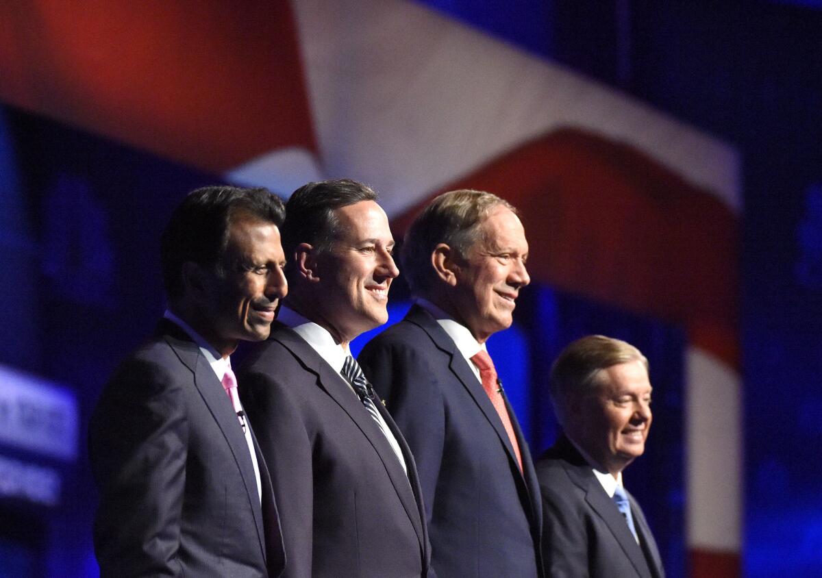 Republican presidential candidates Bobby Jindal, left, Rick Santorum, George Pataki and Lindsey Graham take the stage during the CNBC Republican Presidential Debate.