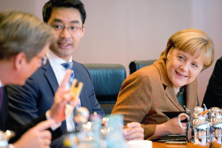 German Chancellor Angela Merkel speaks with government ministers before a Cabinet meeting in Berlin.