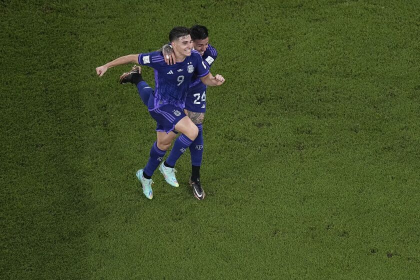 Argentina's Julian Alvarez , left ,celebrates after scoring the second goal of his team against Poland with his teammate Enzo Fernandez during the World Cup group C soccer match between Poland and Argentina at the Stadium 974 in Doha, Qatar, Wednesday, Nov. 30, 2022. (AP Photo/Pavel Golovkin)