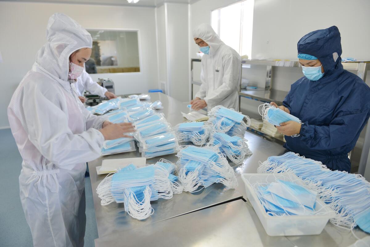 Chinese workers sort masks at a factory in Nanjing in China's Jiangsu province. The factory switched from making surgical instruments and dental equipment to masks to meet increased demand during the COVID-19 pandemic.