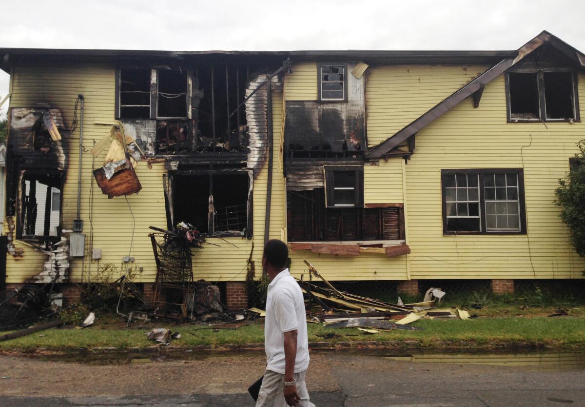 A man walks by a house destroyed by fire in New Orleans on Nov. 11. Firefighters said a grandmother, three grandchildren and the children's mother died.