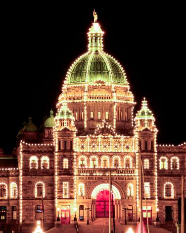 Victoria's Parliament Buildings are lighted up at night.