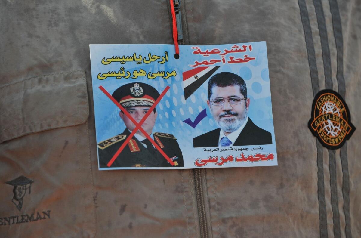A sticker on the shirt of a supporter of Egypt's ousted President Mohamed Morsi depicts Morsi, right, and army chief Gen. Abdel Fattah Sisi.