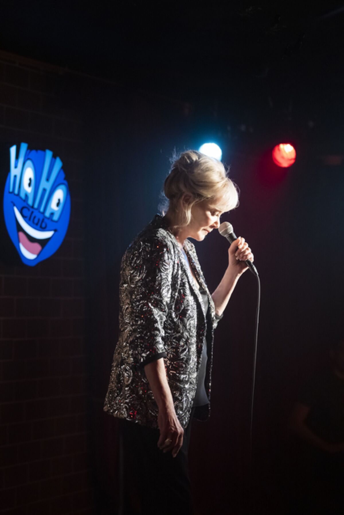 A woman doing stand-up at a comedy club