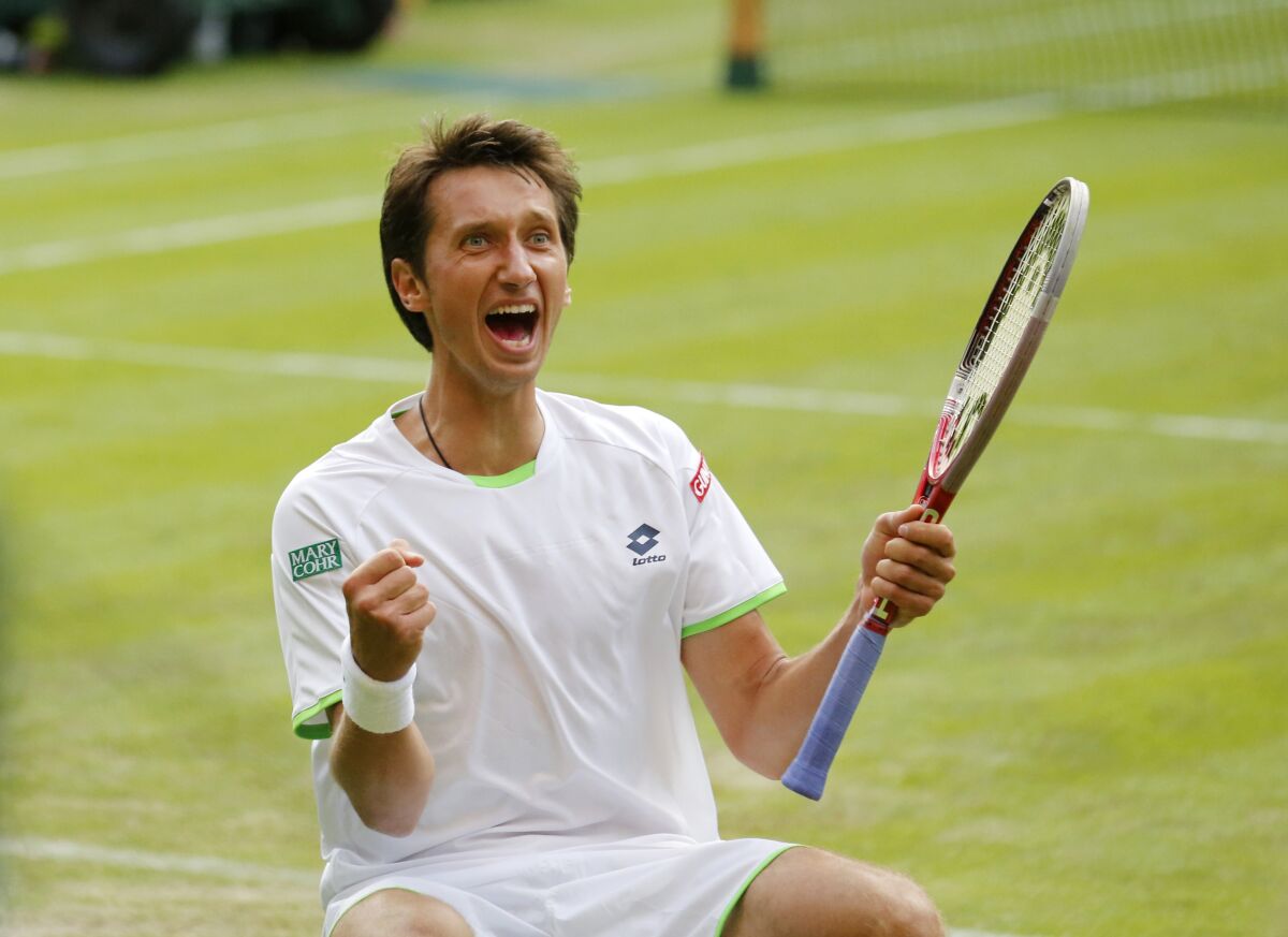 FILE -Sergiy Stakhovsky of Ukraine reacts as he wins against Roger Federer of Switzerland in their men's second round singles match at the All England Lawn Tennis Championships in Wimbledon, London, Wednesday, June 26, 2013. About 1 1/2 months after the last match of Sergiy Stakhovsky’s professional tennis career, the 36-year-old Ukrainian left his wife and three young children in Hungary and went back to his birthplace to help however he could during Russia’s invasion. (AP Photo/Anja Niedringhaus, File)