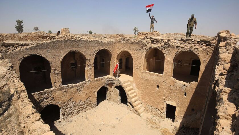 Fighters supporting Iraqi forces pose with the Iraqi flag at Tall Afar's Ottoman-era citadel Aug. 27, 2017.