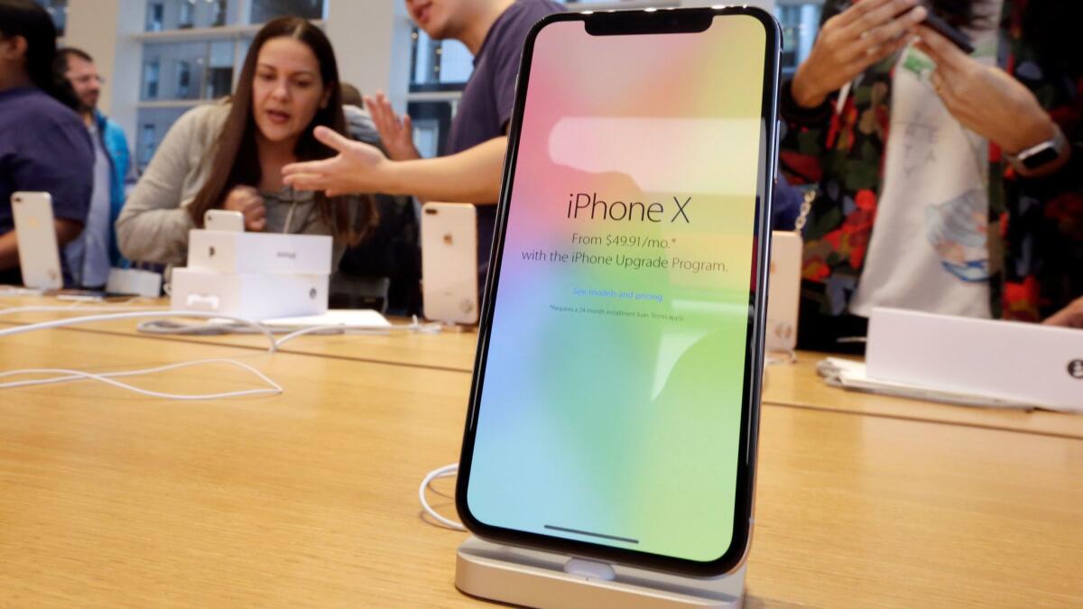 People look at the iPhone X at an Apple Store in New York.