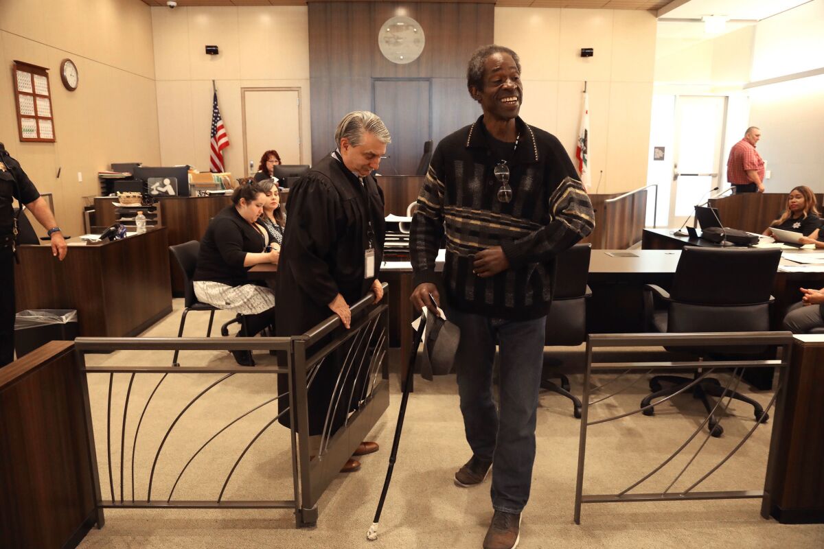 Judge Richard A. Vlavianos, left, opens the gate for probationer Danny Batts during a collaborative court session in Stockton.