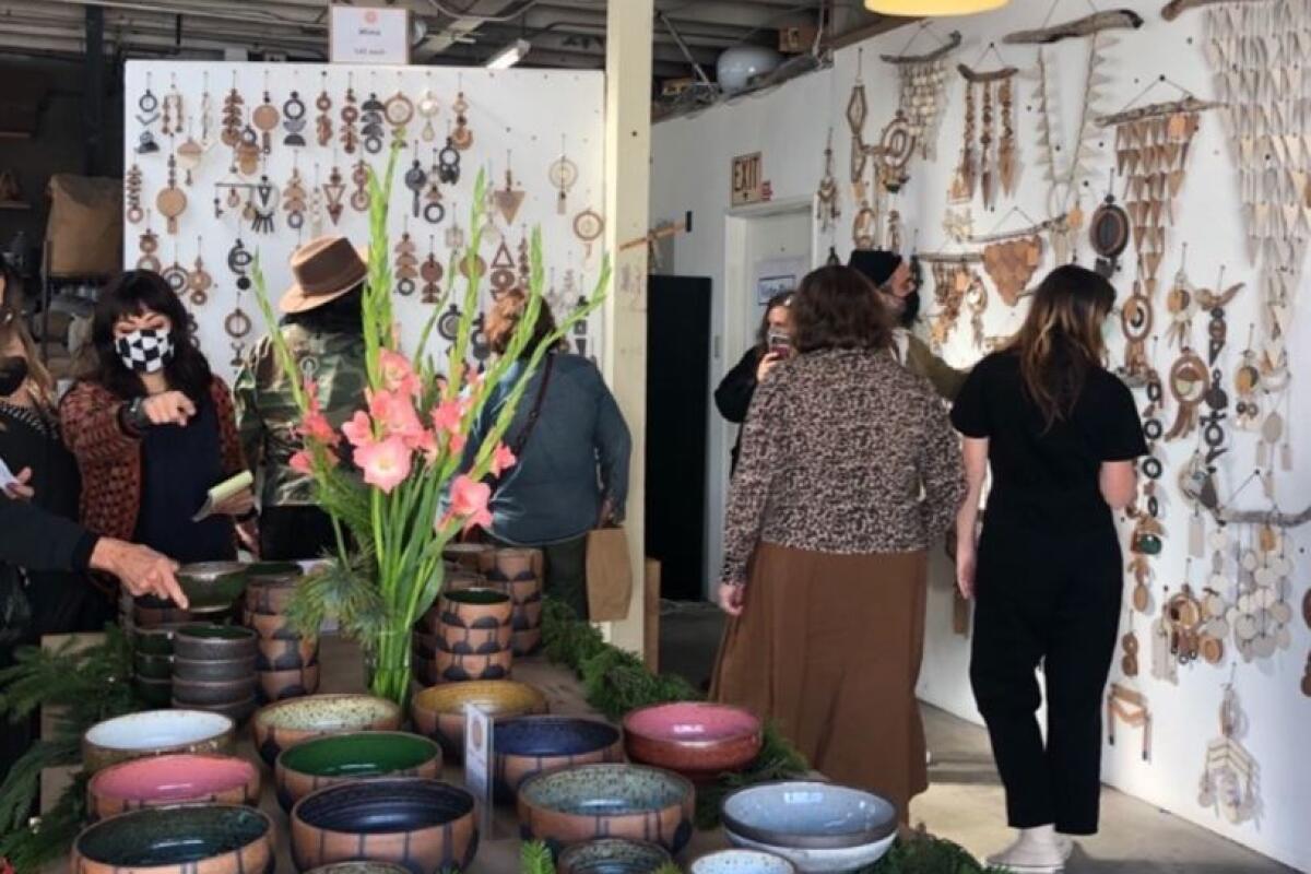 People shop for ceramics in an indoor studio 