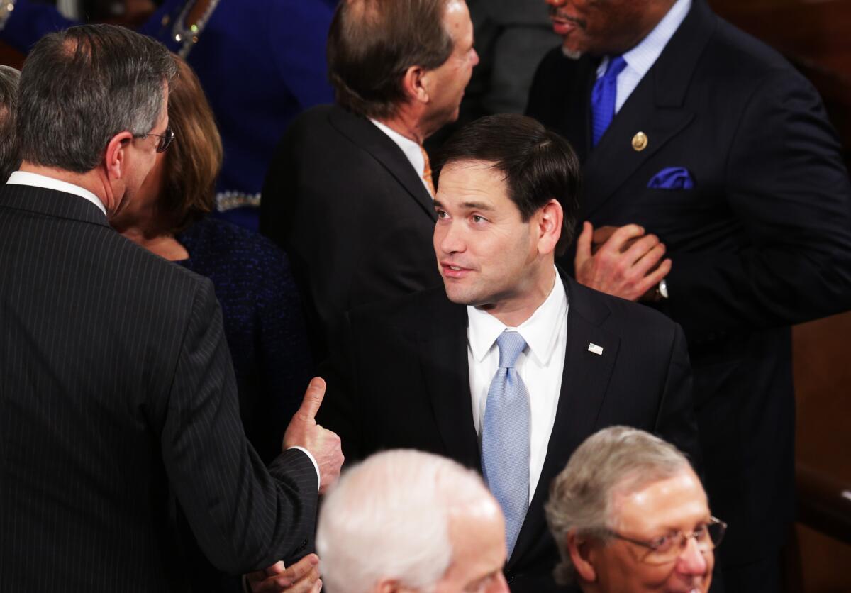 Sen. Marco Rubio (R-Fla.) shakes hands before the start of President Obama's State of the Union speech Tuesday night. Rubio says he will decide soon whether to seek the presidency himself.