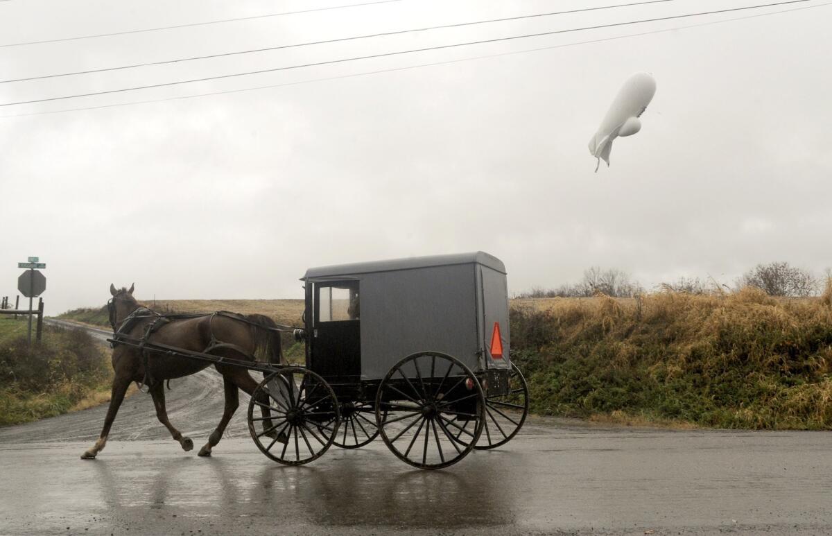 An unmanned Army surveillance blimp floats through the air while dragging a tether line just south of Millville, Pa., on Oct. 28.