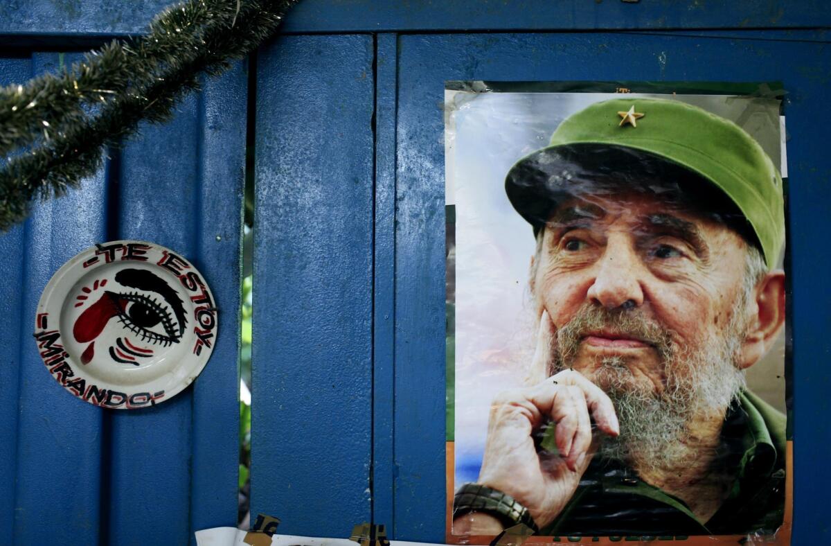 A poster of Cuba's Fidel Castro hangs on the wall of a Havana food market next to plate that reads in Spanish, "I'm looking at you."